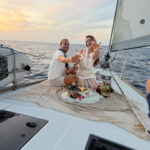 Couple relaxing on deck during sunset ocean charter