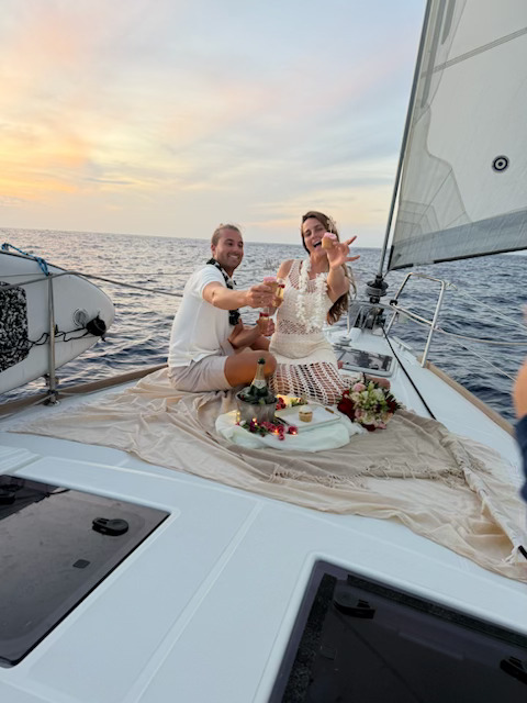 Couple relaxing on deck during sunset ocean charter