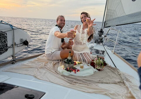 Couple relaxing on deck during sunset ocean charter